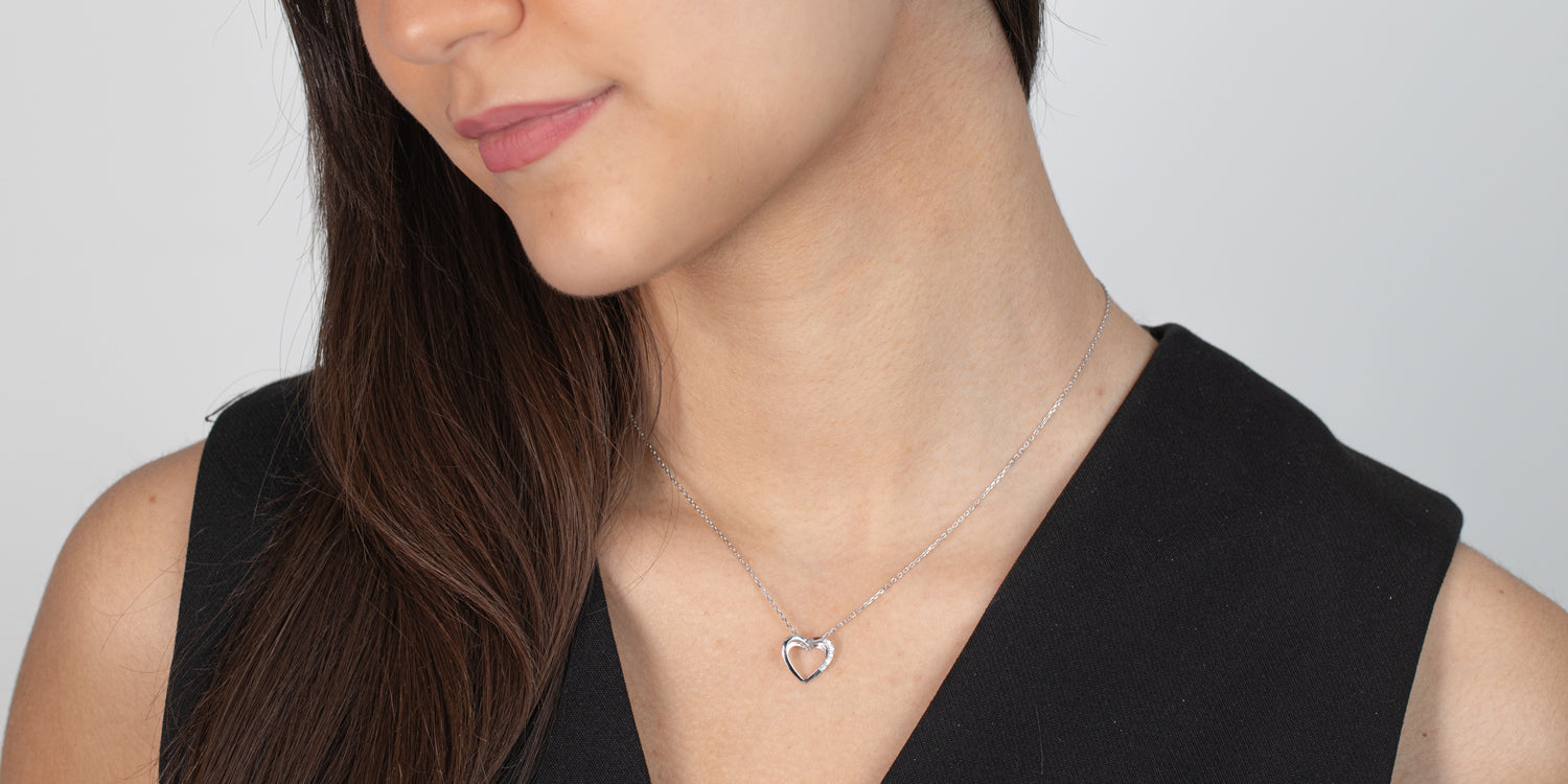 Silberne Herzanhänger-Halskette an Damenhals, zarter Schmuck